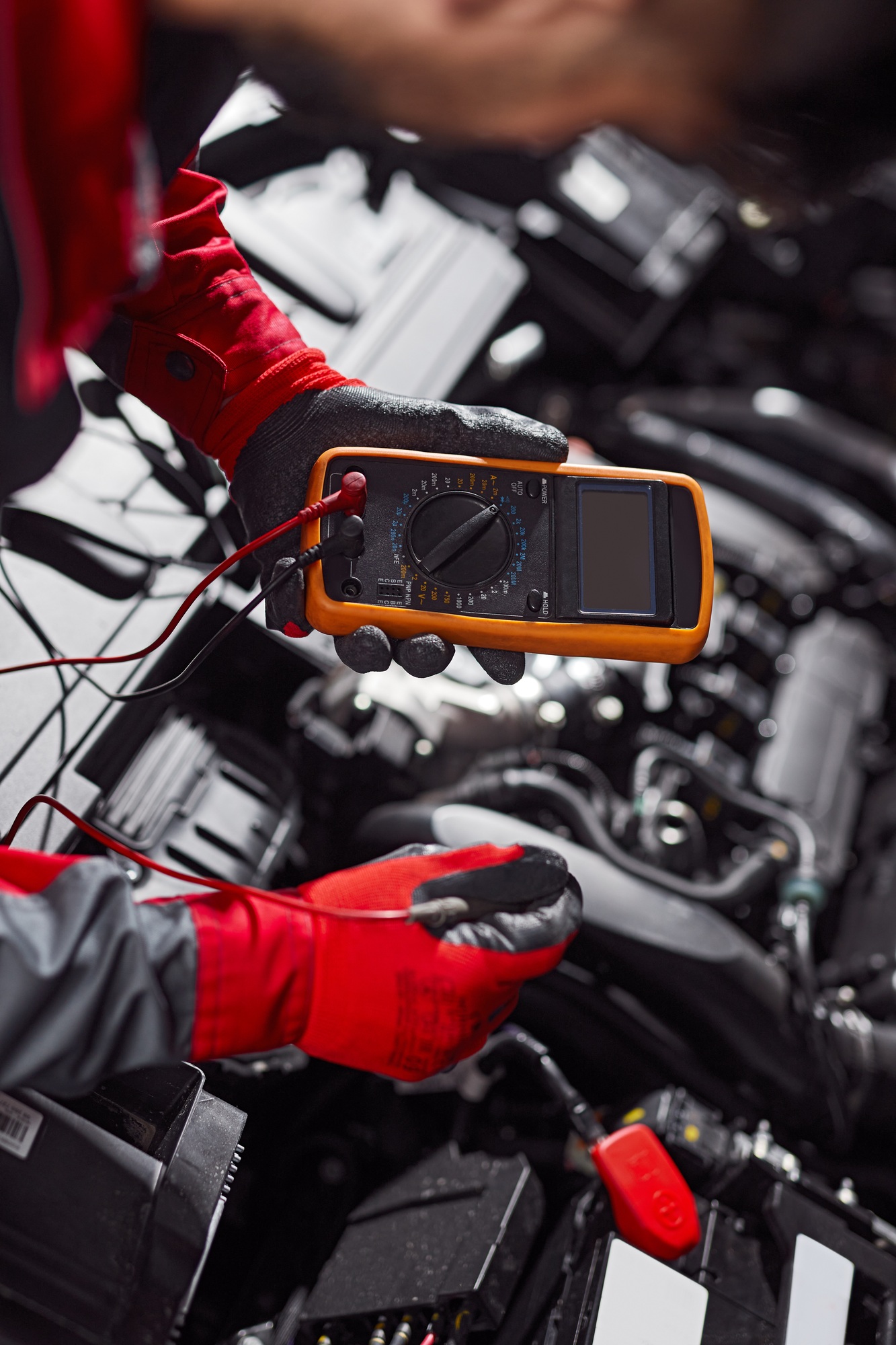 Mechanic checking battery of car in workshop
